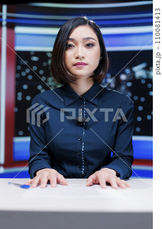 TV reporter discussing about latest news in studio, presenting headlines topics live on television channel. Woman presenter covering all essential news stories, global communications. TV reporter discussing about latest news in studio, presenting headlines topics live on television channel. Woman presenter covering all essential news stories, global communications. 110081413