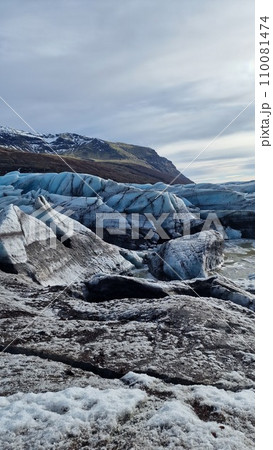 Glacier hiking vatnajokull ice cap in iceland with freezing cold icy blocks on scandinavian big lake, icelandic landscape. Majestic arctic icebergs near brown frosty hills and snowy fields. 110081474