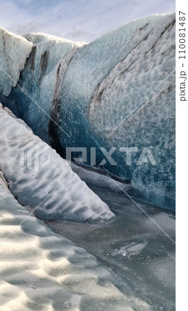 Vatnajokull glacier ice mass in nordic region, spectacular ice rocks with large caves around snowy mountain chain. Majestic frozen icebergs fragments floating on lake, scenic route. 110081487