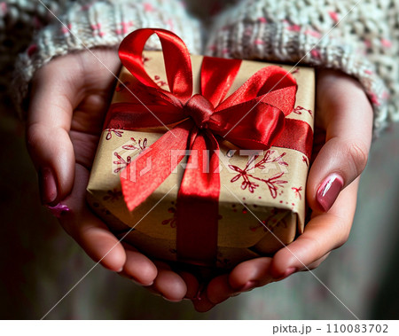 赤いリボンのギフトボックスを渡す手 110083702