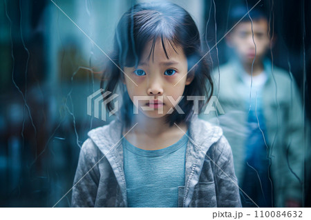 AI-generated content. Defocused little Asian girl looking through the window in a rainy day. AI-generated content. Defocused little Asian girl looking through the window in a rainy day. 110084632