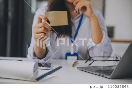 .Women holding credit card and using smartphones at home.Online shopping, internet banking, store online, payment, spending money, e-commerce payment at the store, credit card, concept .Women holding credit card and using smartphones at home.Online shopping, internet banking, store online, payment, spending money, e-commerce payment at the store, credit card, concept 110085848