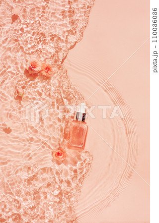 Cosmetics on a water background with flowers in trendy peach colour. Abstract backdrop for product presentation for women's day. Cosmetics on a water background with flowers in trendy peach colour. Abstract backdrop for product presentation for women's day. 110086086