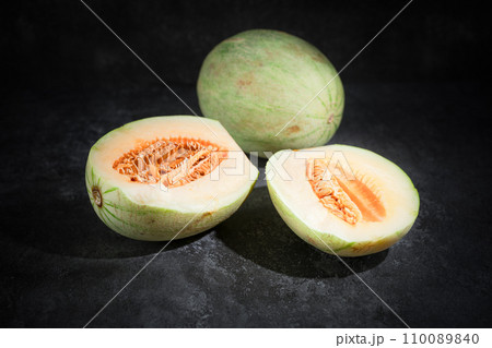 Fresh honeydew melon on dark background Fresh honeydew melon on dark background 110089840