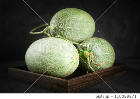 Fresh honeydew melon on dark background Fresh honeydew melon on dark background 110089871