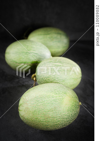 Fresh honeydew melon on dark background Fresh honeydew melon on dark background 110089882
