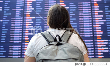 Woman looks at plane schedule and looks for needed flight 110090004