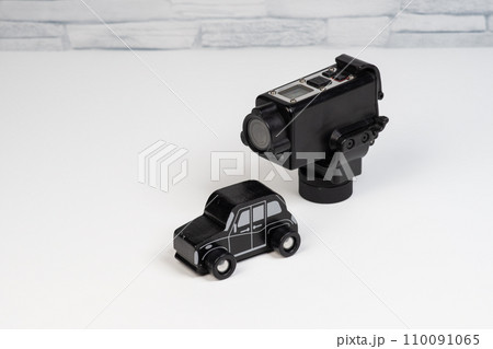 木製のおもちゃの自動車と防犯カメラ 110091065