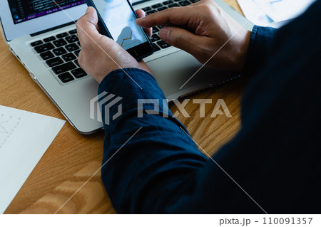 パソコンとスマホを操作する男性の手元 110091357