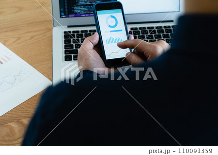 パソコンとスマホを操作する男性の手元 110091359