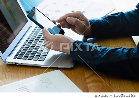 パソコンとスマホを操作する男性の手元 110091365