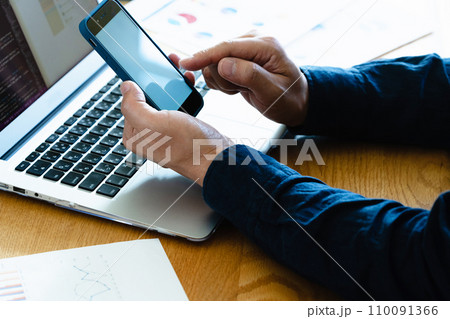 パソコンとスマホを操作する男性の手元 110091366
