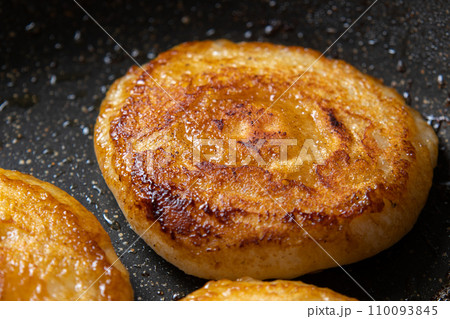 餅(丸餅)をフライパンでバター醤油焼きする、調理シーン。余った餅リメイクイメージ。 110093845