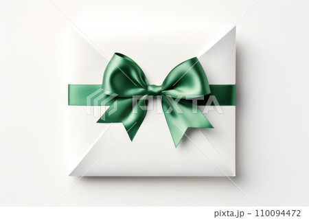 White gift box tied with green ribbon and bow on white background 110094472