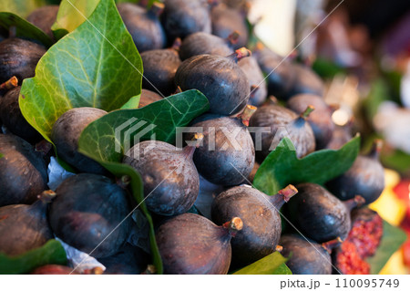 Ripe figs with leaves on counter in market 110095749