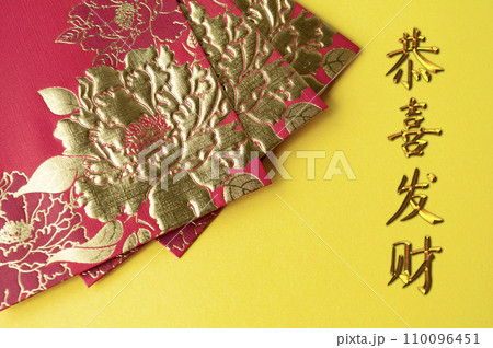 Chinese New Year red packets on yellow cover background with GongXi FaCai wishes 110096451