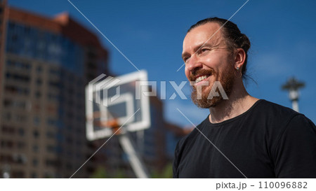 Portrait of a Caucasian bearded man on a basketball court outdoors.  110096882