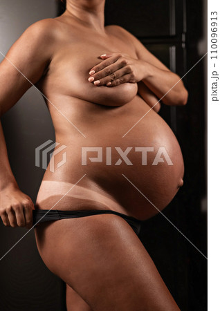 Pregnant woman pulls back her panties showing instant tan. Pregnant woman pulls back her panties showing instant tan. 110096913