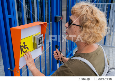 An elderly woman reading a text in braille. Button for calling help for people with disabilities. An elderly woman reading a text in braille. Button for calling help for people with disabilities. 110097446