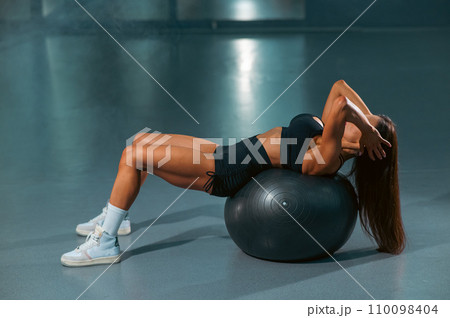 Caucasian woman doing abdominal exercise on fitball. Caucasian woman doing abdominal exercise on fitball. 110098404