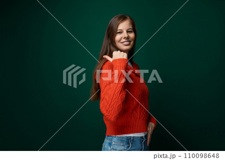Positive pretty caucasian woman with brown straight hair wearing a red sweater Positive pretty caucasian woman with brown straight hair wearing a red sweater 110098648