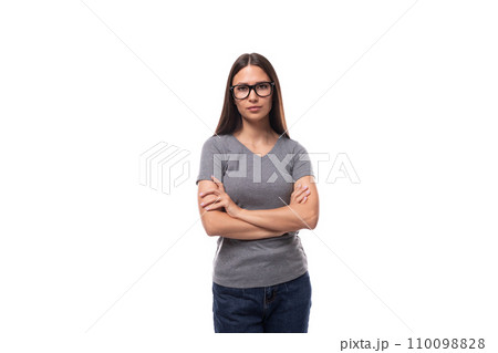 portrait of a caucasian slim young woman in glasses dressed in a gray basic t-shirt and jeans 110098828