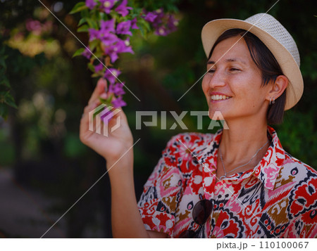 young woman stands in sunny green park young woman stands in sunny green park 110100067