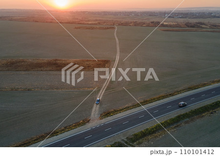 Aerial view of intercity road with fast driving cars at sunset. Top view from drone of highway traffic in evening Aerial view of intercity road with fast driving cars at sunset. Top view from drone of highway traffic in evening 110101412
