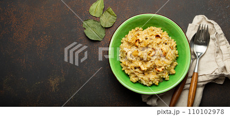 Ven Pongal (Khara Pongal), traditional Indian savoury rice dish made during celebrating Pongal festival, served in bowl top view on concrete rustic background, space for text Ven Pongal (Khara Pongal), traditional Indian savoury rice dish made during celebrating Pongal festival, served in bowl top view on concrete rustic background, space for text 110102978