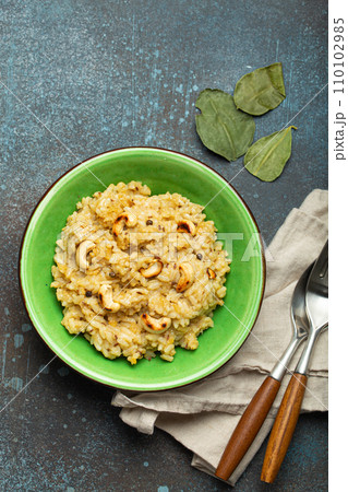 Ven Pongal (Khara Pongal), traditional Indian savoury rice dish made during celebrating Pongal festival, served in bowl top view on concrete rustic background Ven Pongal (Khara Pongal), traditional Indian savoury rice dish made during celebrating Pongal festival, served in bowl top view on concrete rustic background 110102985