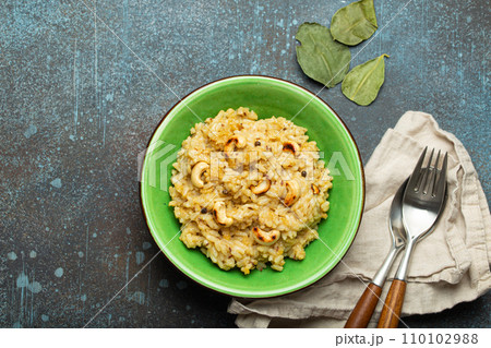 Ven Pongal (Khara Pongal), traditional Indian savoury rice dish made during celebrating Pongal festival, served in bowl top view on concrete rustic background Ven Pongal (Khara Pongal), traditional Indian savoury rice dish made during celebrating Pongal festival, served in bowl top view on concrete rustic background 110102988