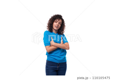 a young woman with a curly hairstyle above her shoulders in blue comfortable clothes feels confident 110105475
