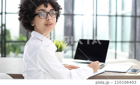 Portrait of Young Successful Caucasian Businesswoman Sitting at Desk Working on Laptop 110106403
