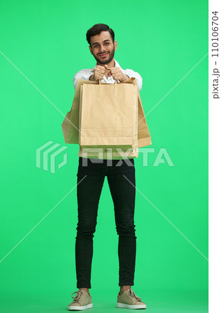 Man on a green background with shoppers Man on a green background with shoppers 110106704