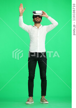full-length man on a green background wearing 3D augmented reality glasses 110106710