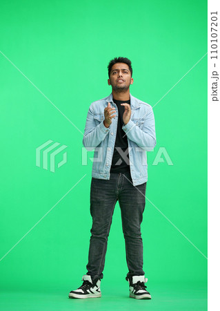 a man on a green background rejoices and claps 110107201