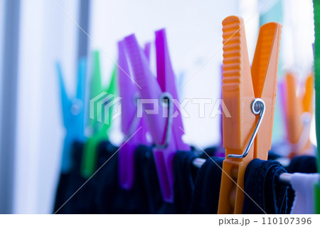 Clothespins holding clothes on clothesline. Various colors. Clothespins holding clothes on clothesline. Various colors. 110107396
