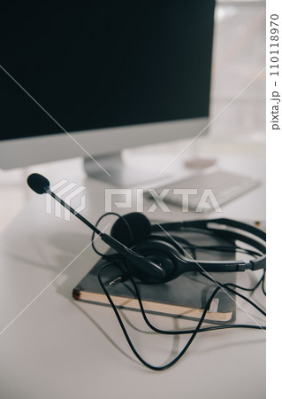 Communication support, call center and customer service help desk. VOIP headset on telephone keyboard. 110118970