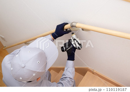 階段に手すりを取り付け作業　工事現場 110119187