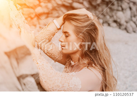 Woman summer travel sea. Happy tourist in beige dress enjoy taking picture outdoors for memories. Woman traveler posing on the beach surrounded by volcanic mountains, sharing travel adventure journey Woman summer travel sea. Happy tourist in beige dress enjoy taking picture outdoors for memories. Woman traveler posing on the beach surrounded by volcanic mountains, sharing travel adventure journey 110120537