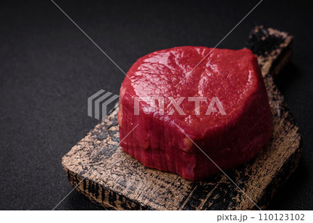 Fresh juicy raw filet mignon with salt, spices and herbs 110123102