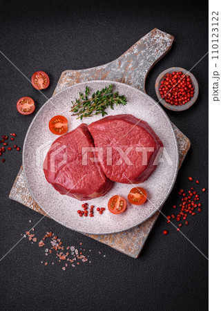 Fresh juicy raw filet mignon with salt, spices and herbs 110123122