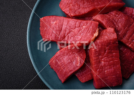 Juicy fresh raw beef meat with salt, spices and herbs Juicy fresh raw beef meat with salt, spices and herbs 110123176