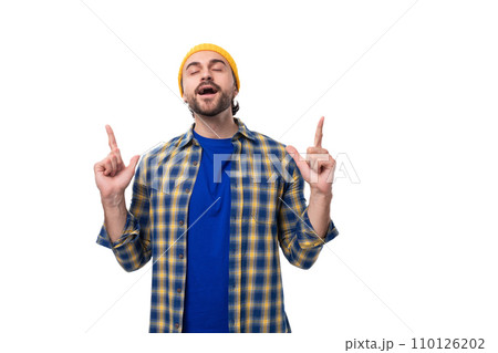 young pensive smart European brunette man with a beard and mustache is dressed in a yellow hat and 110126202