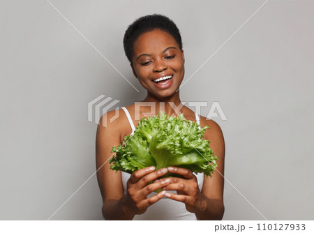 Healthy woman holding vegetable green lettuce on white background. Healthy lifestyle, Vegan 110127933
