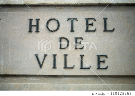 Closeup of french city hall signage on stoned building facade, with text in french, hotel de ville, traduction in english Closeup of french city hall signage on stoned building facade, with text in french, hotel de ville, traduction in english 110128262