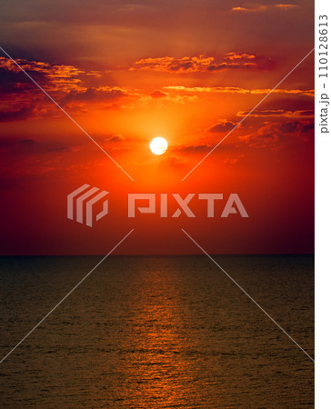 Tropical beach, blue sea and bright sun set. Vertical photo. 110128613