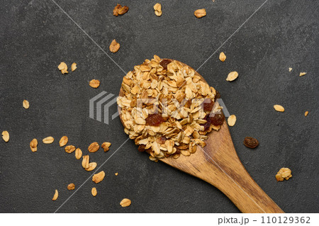 Oatmeal, raisins, cashews and almonds. Granola in a wooden spoon, top view 110129362