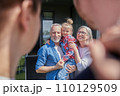 Senior couple holding little girl at the hands and feeling happy at the summer 110129509