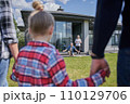 Little girl holding hands of father and mother while meeting her senior grandparents 110129706